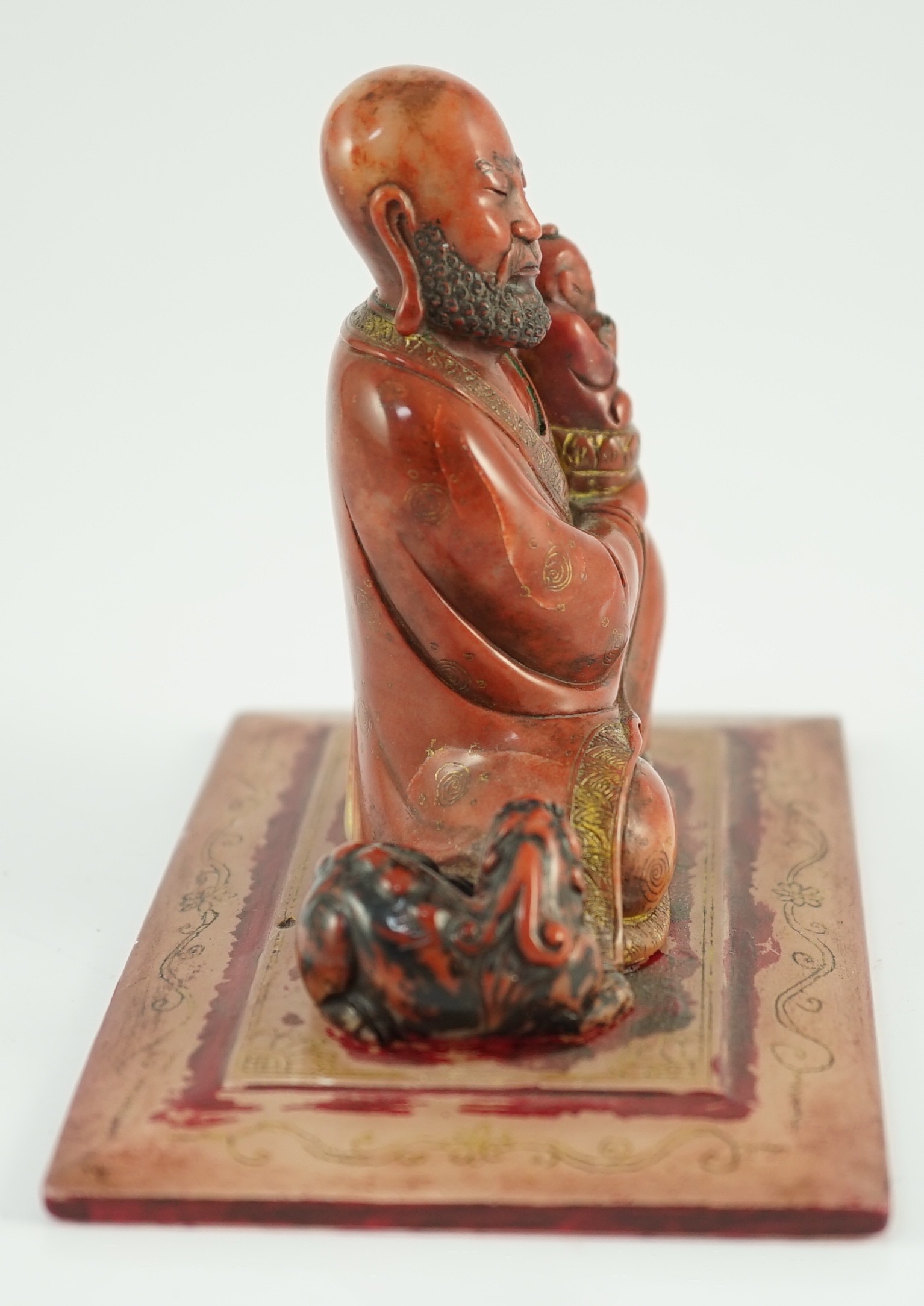 A Chinese soapstone group of a luohan holding a figure of Buddha, 18th century, 12cm wide, 9cm high